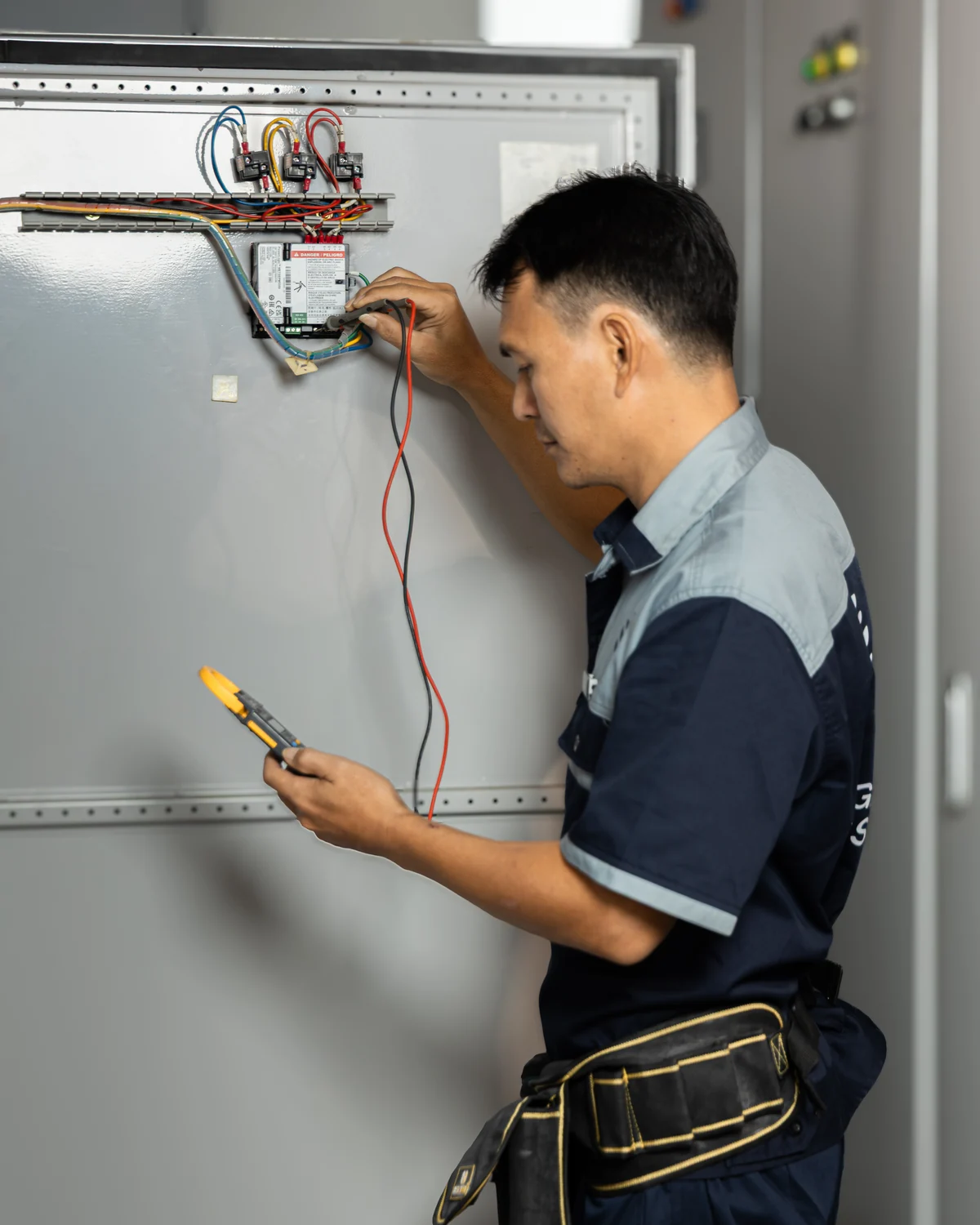 Legacy Asset technician inspecting an electrical control panel